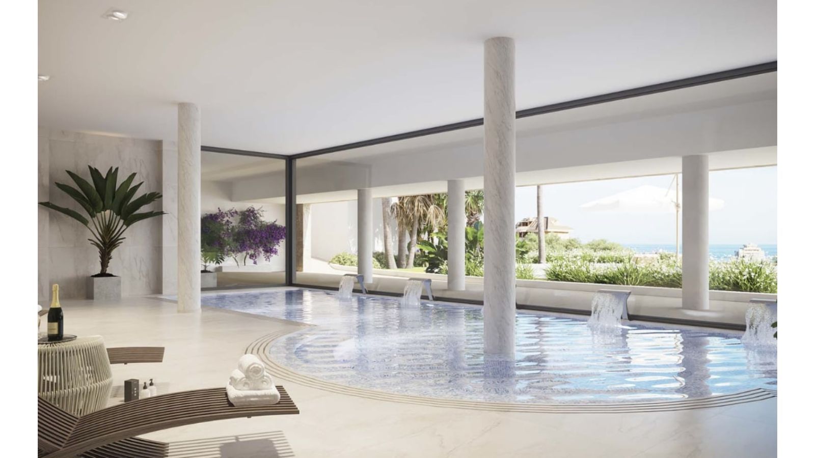 Lujosa piscina interior con cascadas y vista al mar, ideal para la relajación.