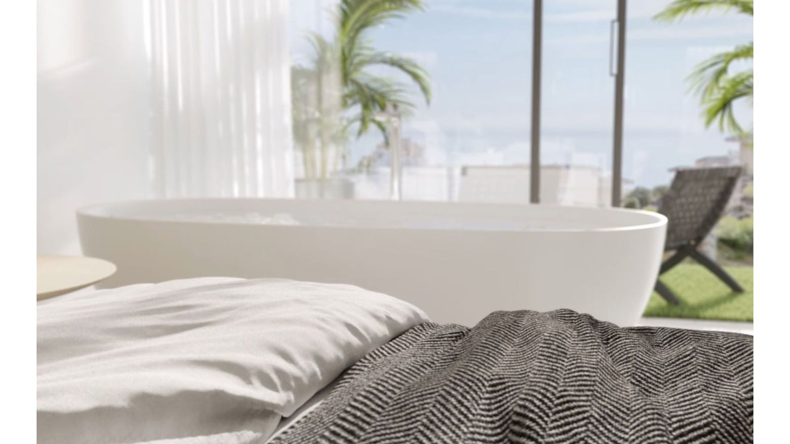 Lujosa bañera exenta con vistas al balcón y exuberantes palmeras.